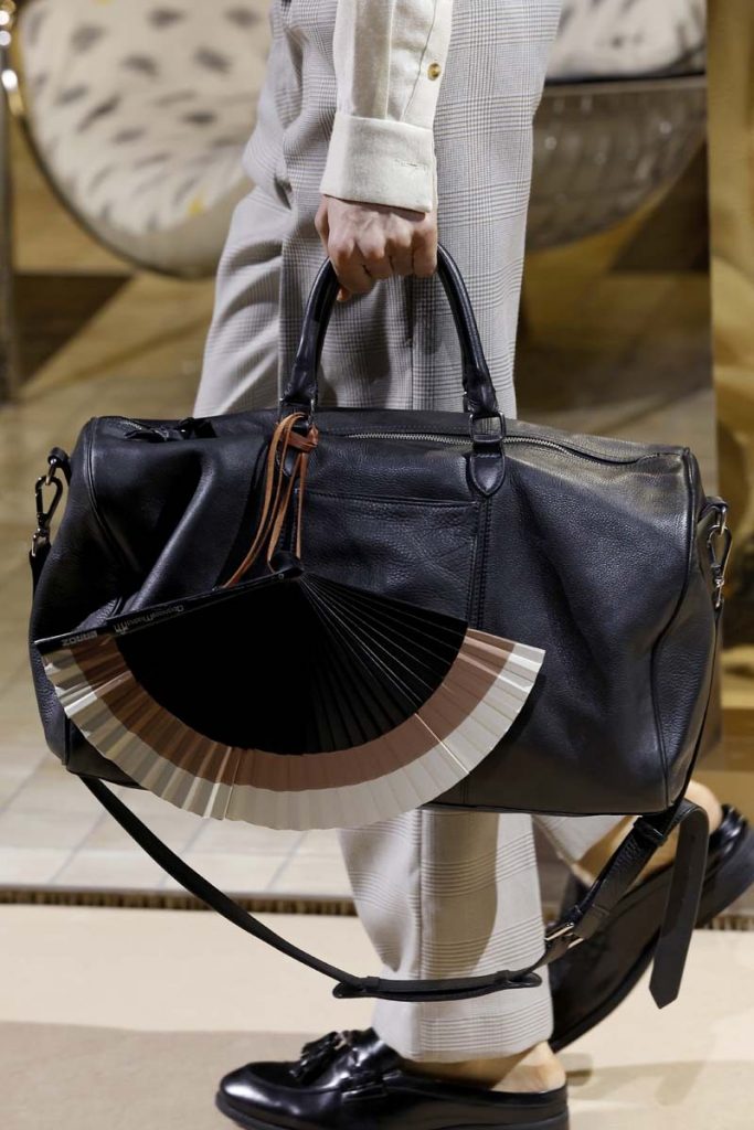 Detalle de un abanico pintado a mano con varillaje de madera noble en la MBFW Madrid